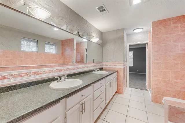 a spacious bathroom with a granite countertop sink a toilet a mirror and bathtub