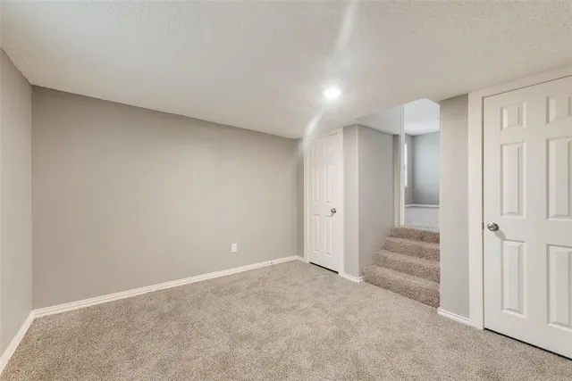 a view of a white house with a big yard and large trees