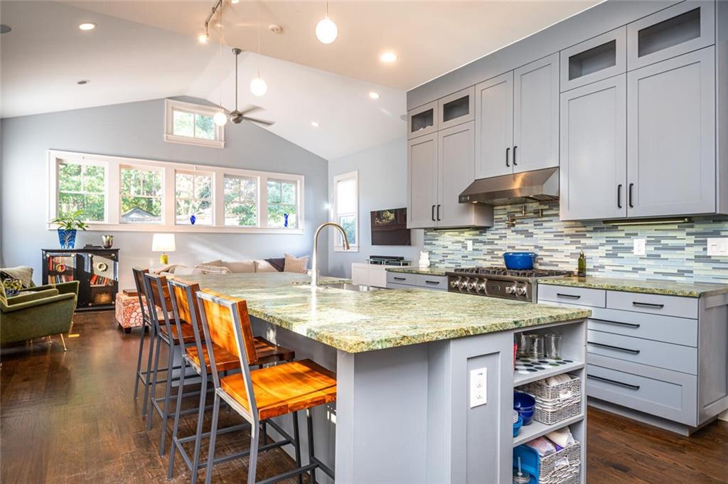 123 Ansley Street Decatur, GA 30030 - Photo 18 of 61 a kitchen with stainless steel appliances granite countertop a stove a refrigerator a sink a dining table and chairs with wooden floor