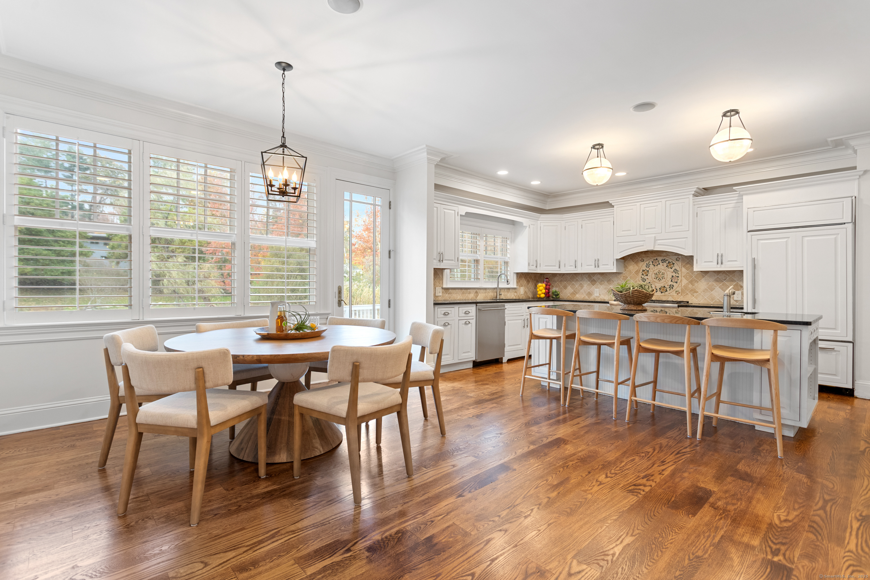 123 Greens Farms Road Westport, CT 06880 - Photo 11 of 40 a kitchen with stainless steel appliances kitchen island granite countertop a dining table chairs and white cabinets