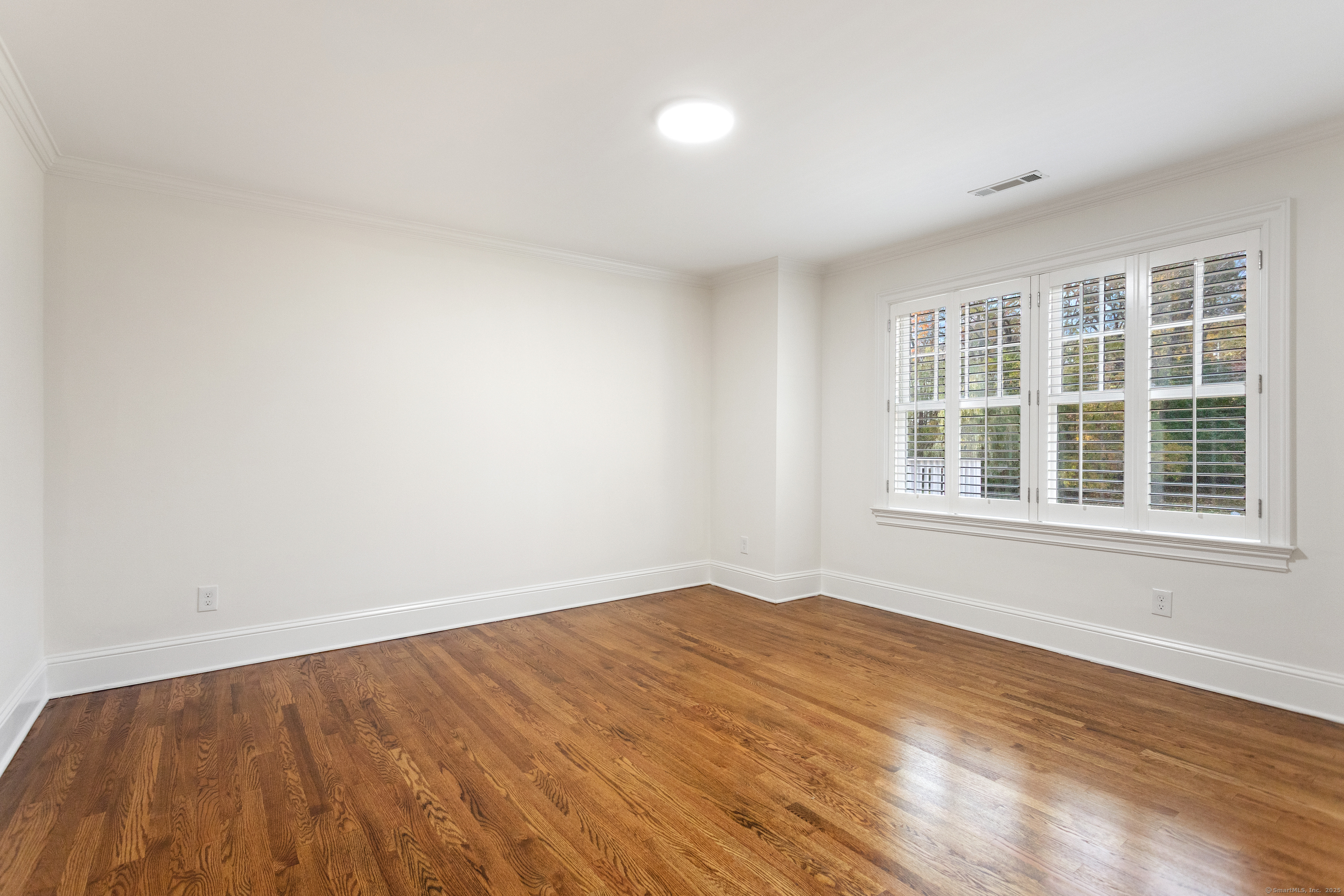 123 Greens Farms Road Westport, CT 06880 - Photo 25 of 40 a view of an empty room with wooden floor and a window