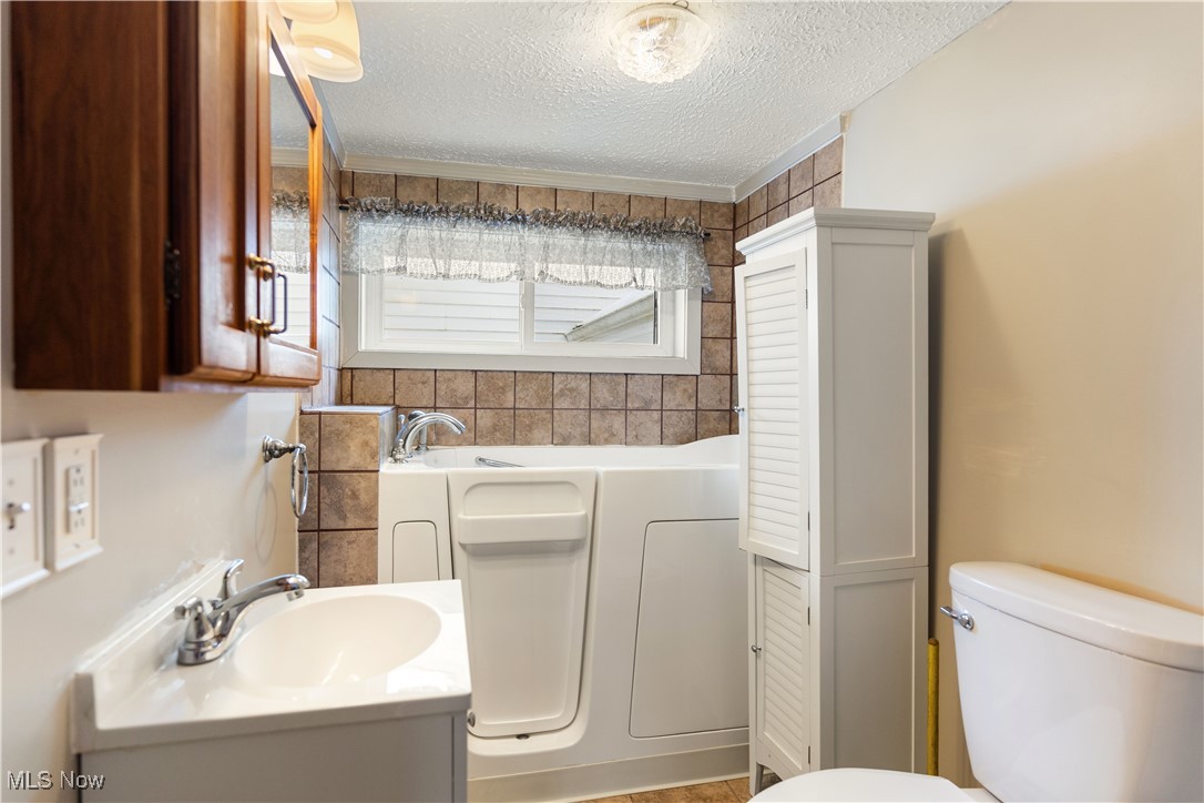 5070 Russell Road Andover, OH 44003 - Photo 20 of 25 Bathroom featuring a wealth of natural light, a textured ceiling, and toilet