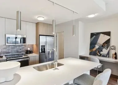 a kitchen with stainless steel appliances kitchen island granite countertop a sink and refrigerator