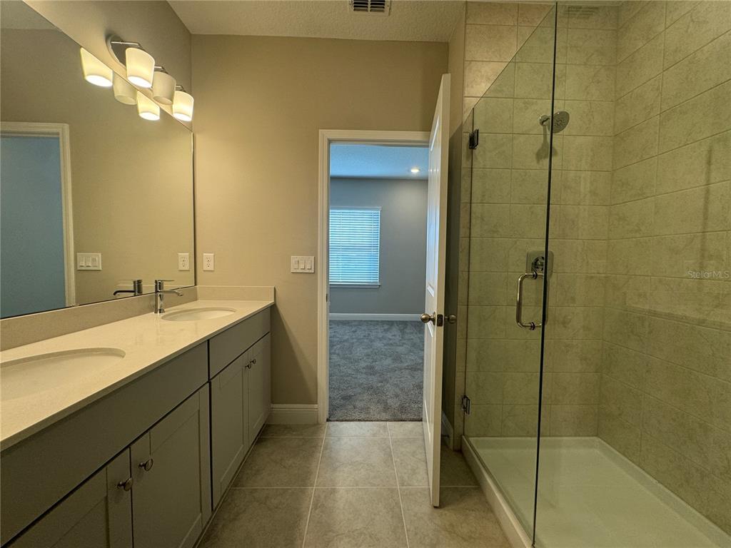16333 Hamlin Hills Road Winter Garden, FL 34787 - Photo 32 of 35 a bathroom with a double vanity sink mirror and shower