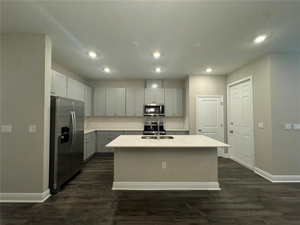16333 Hamlin Hills Road Winter Garden, FL 34787 - Photo 9 of 35 a view of kitchen with refrigerator stove and wooden cabinets