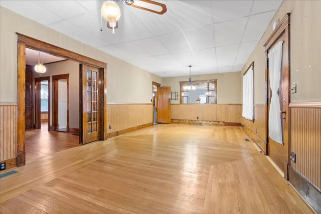 a view of an empty room with a window and wooden floor