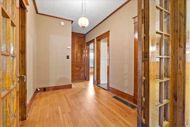 a view of a hallway with wooden floor and staircase