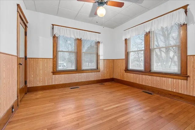 a view of an empty room with a window and wooden floor
