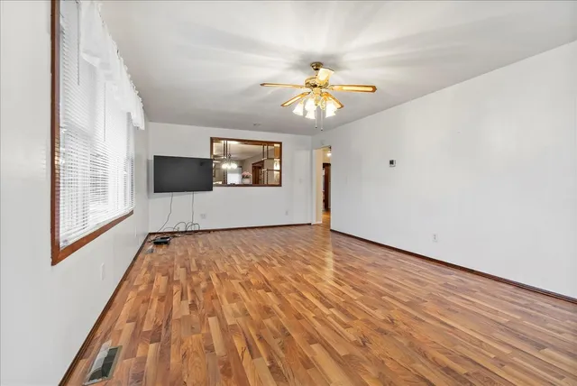 wooden floor in an empty room with a window