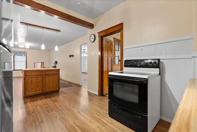a kitchen with stainless steel appliances a stove a microwave and a hard wood floor