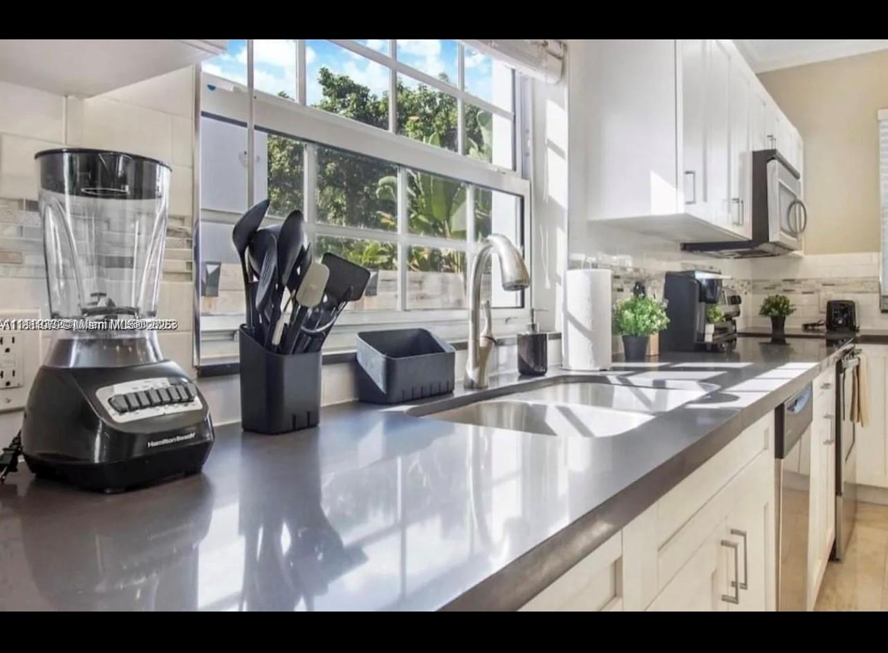 149 Northwest 48th Street Miami, FL 33127 - Photo 11 of 24 a kitchen with sink refrigerator and cabinets