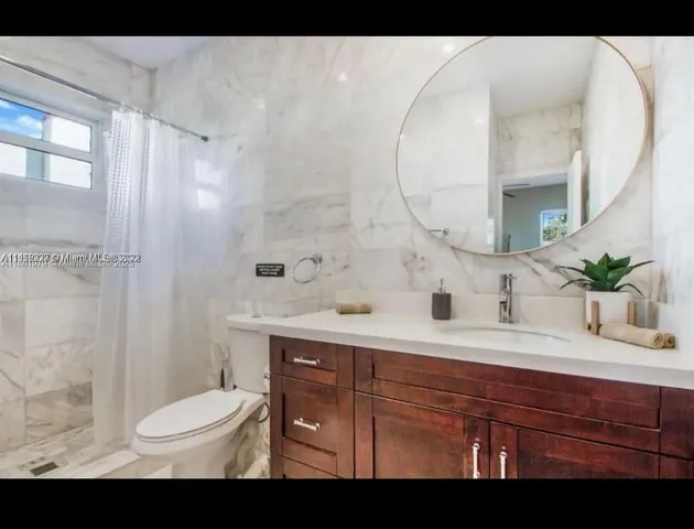 a bathroom with a sink a toilet and a mirror