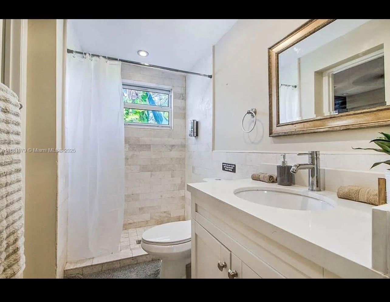 149 Northwest 48th Street Miami, FL 33127 - Photo 6 of 24 a bathroom with a sink a toilet and a mirror