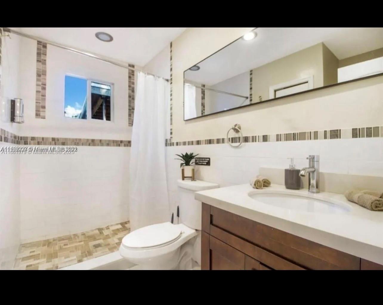149 Northwest 48th Street Miami, FL 33127 - Photo 9 of 24 a bathroom with a sink toilet a mirror and vanity