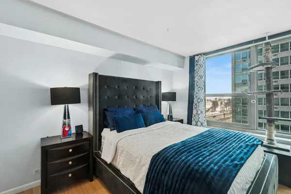 a bedroom with a large bed and a flat tv screen on dresser