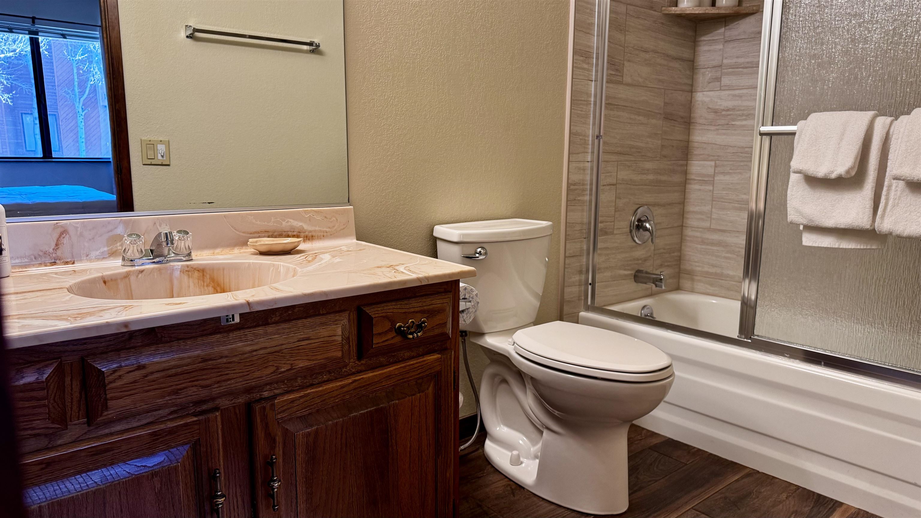 4710 Minaret Road, Unit 87 Mammoth Lakes, CA 93546 - Photo 32 of 44 Full bath with a textured wall, shower / bath combination with glass door, dark wood-type flooring, and vanity