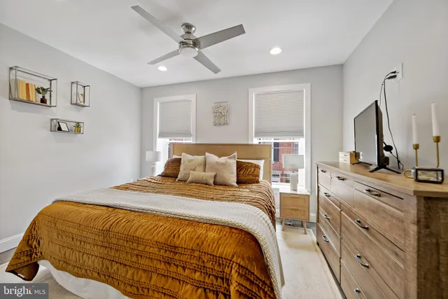 a bedroom with a bed a window and dresser