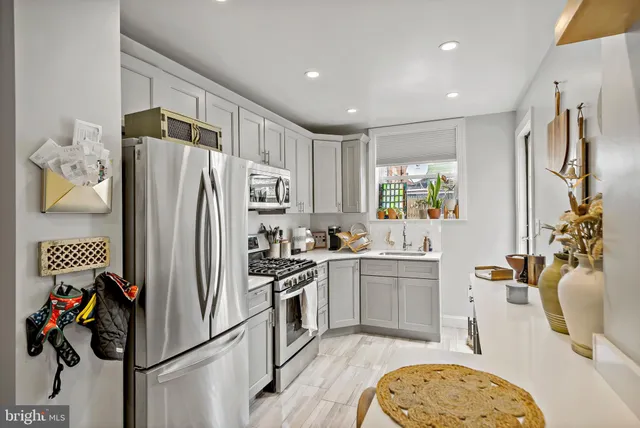 a kitchen with stainless steel appliances granite countertop a refrigerator sink and stove