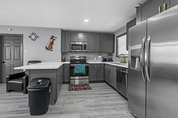 a kitchen with granite countertop a refrigerator stove and sink