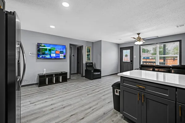 a kitchen with stainless steel appliances wooden floor and a refrigerator
