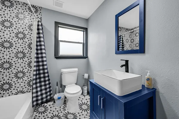 a bathroom with a sink a toilet and a mirror