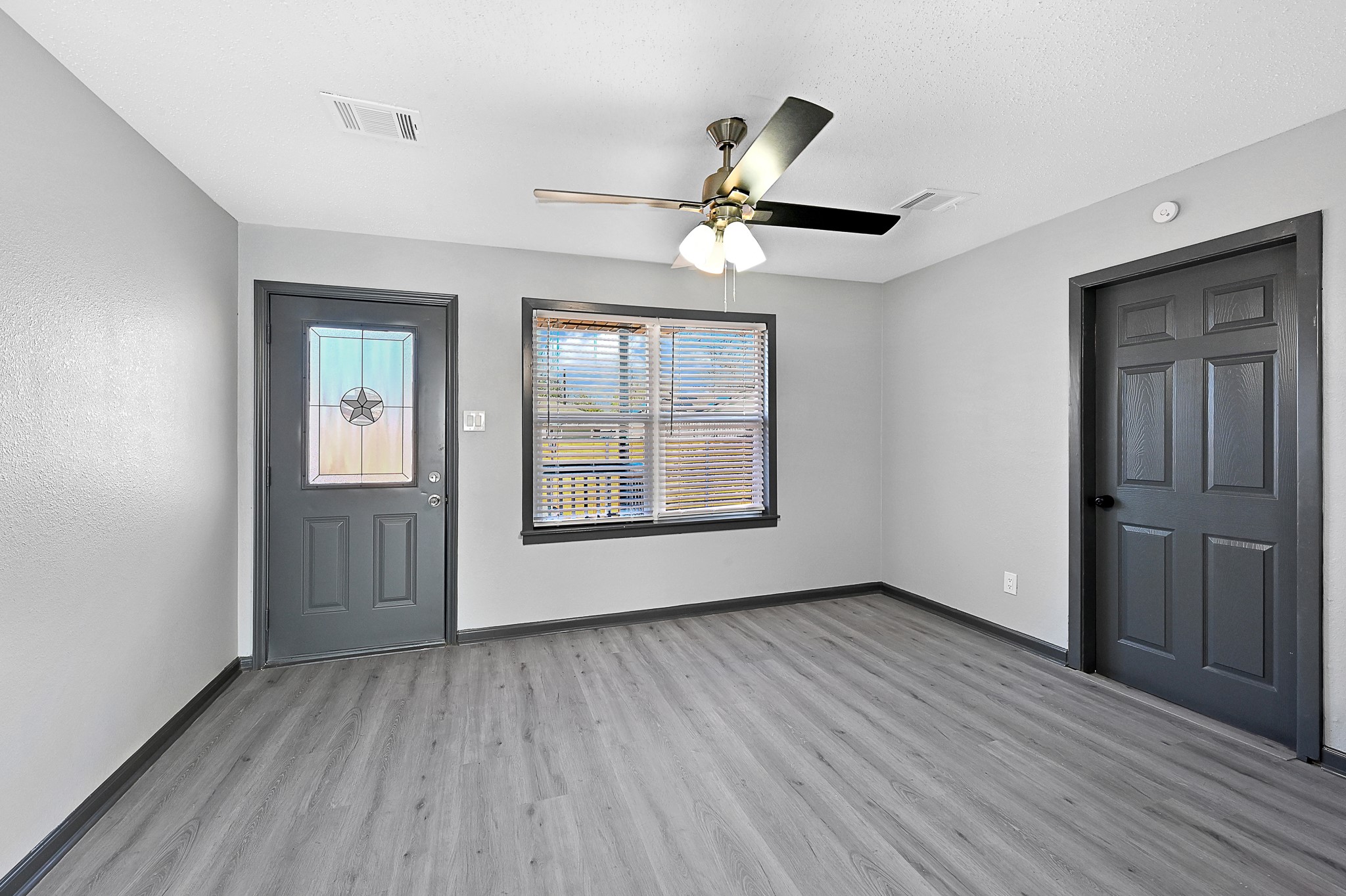 4406 Edison Street Houston, TX 77009 - Photo 5 of 42 a view of an empty room with a window and wooden floor