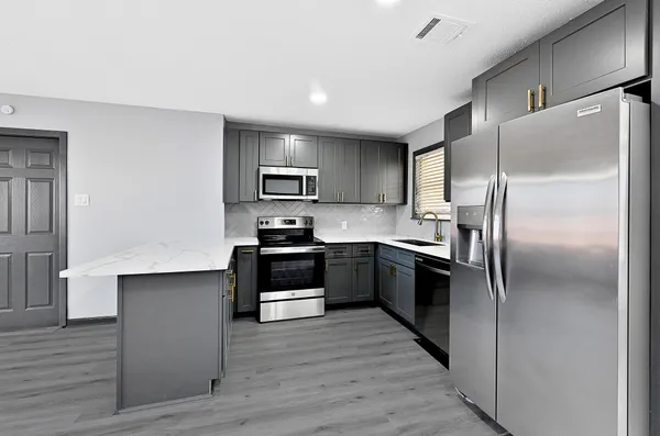 a large kitchen with a refrigerator cabinets and stainless steel appliances