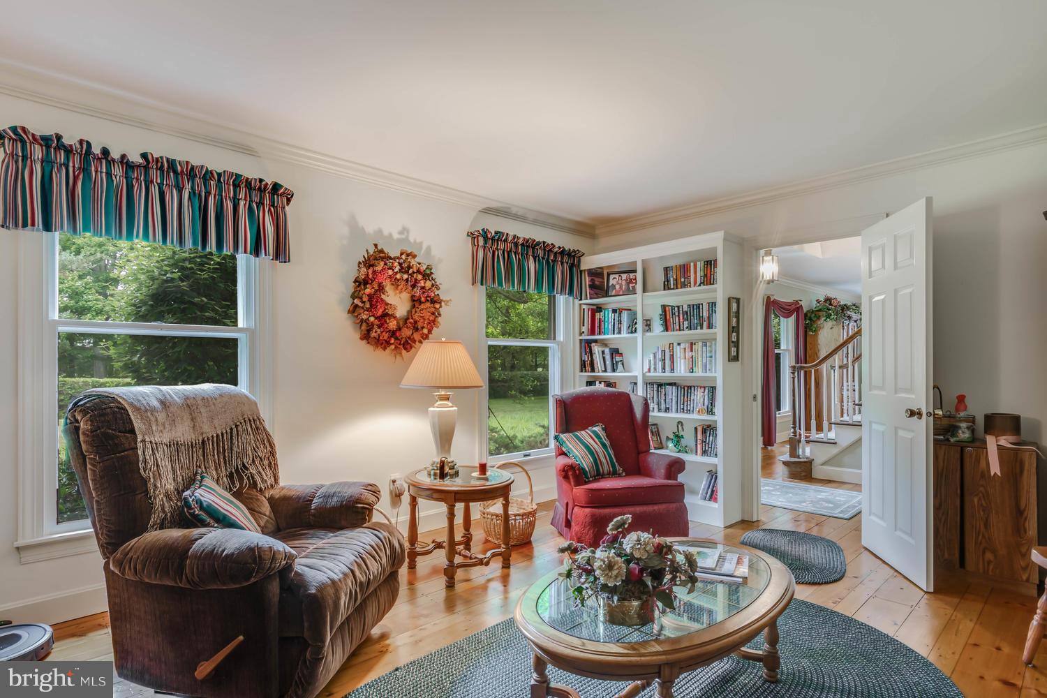 7301 Solitude Road St. Michaels, MD 21663 - Photo 23 of 30 a living room with furniture a rug and a bookshelf