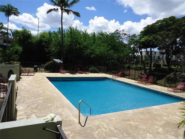 a view of a swimming pool with a patio and a yard