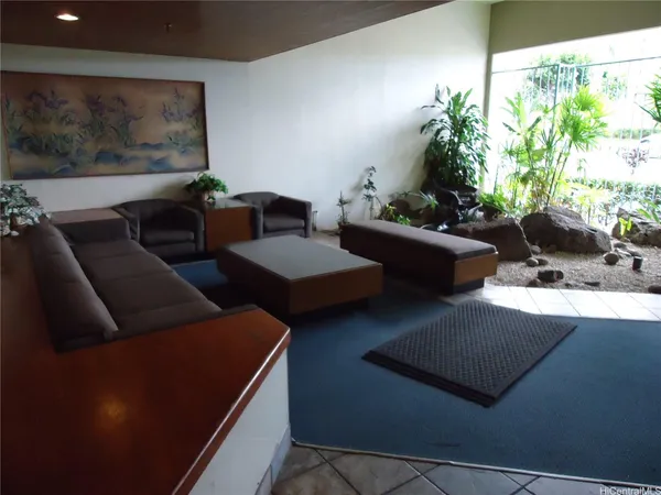 a living room with couches and a potted plant