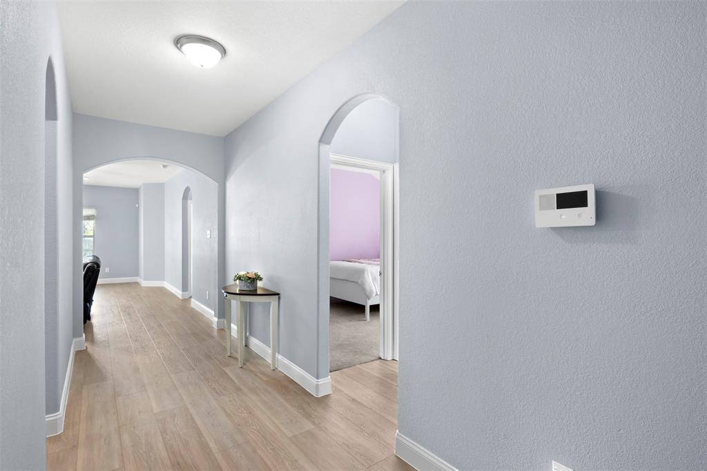 1318 Exeter Avenue Dallas, TX 75216 - Photo 19 of 31 a view of a hallway with wooden floor and a bathroom