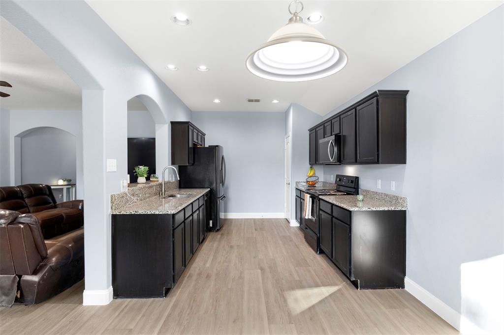 1318 Exeter Avenue Dallas, TX 75216 - Photo 29 of 31 a kitchen with stainless steel appliances granite countertop a sink stove and refrigerator