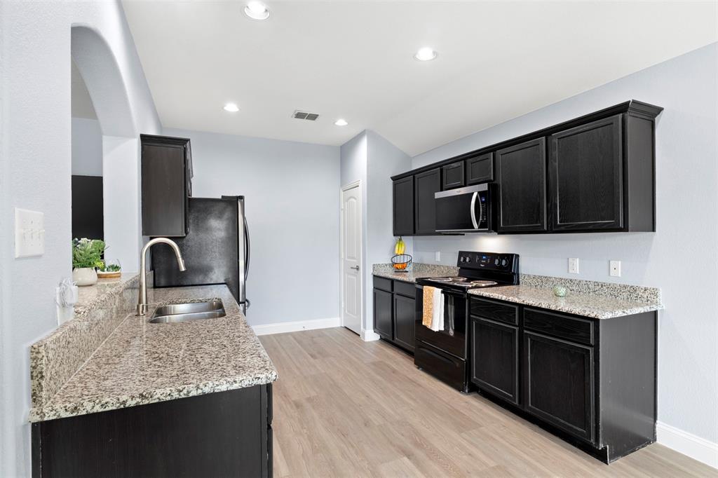 1318 Exeter Avenue Dallas, TX 75216 - Photo 23 of 31 a kitchen with stainless steel appliances granite countertop a sink stove and refrigerator