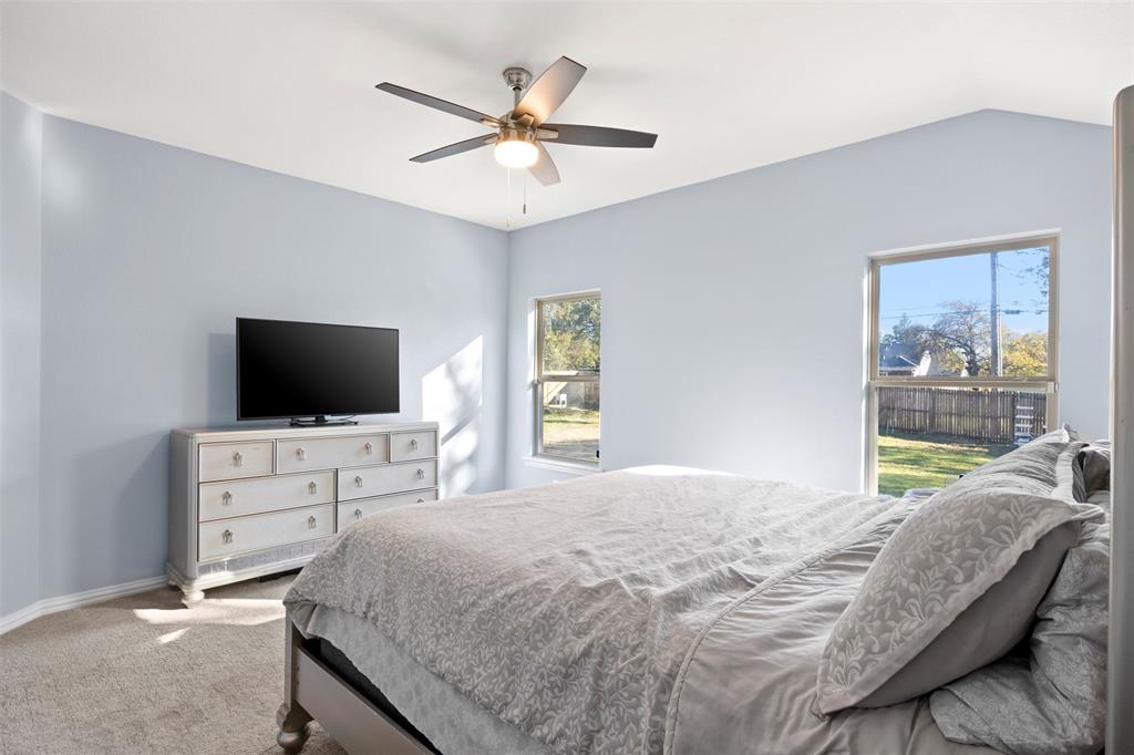 1318 Exeter Avenue Dallas, TX 75216 - Photo 27 of 31 a bedroom with a large bed and a flat screen tv