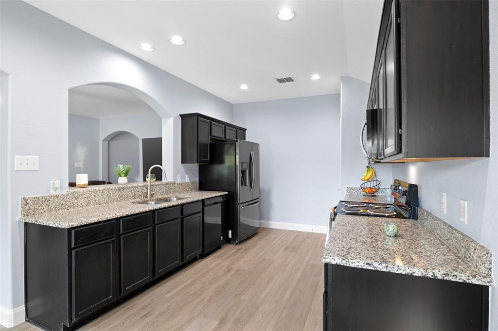 1318 Exeter Avenue Dallas, TX 75216 - Photo 5 of 31 a kitchen with stainless steel appliances granite countertop a sink stove and refrigerator