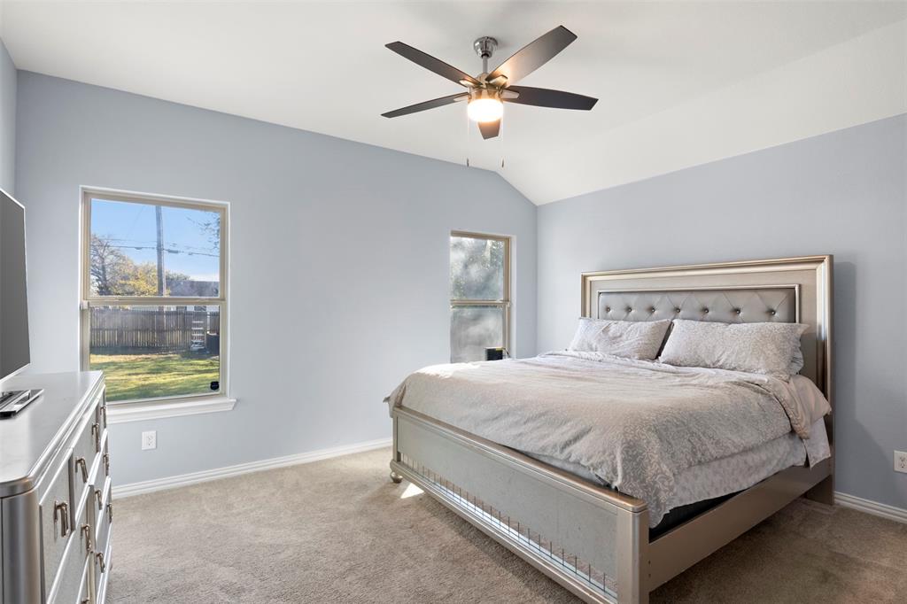 1318 Exeter Avenue Dallas, TX 75216 - Photo 8 of 31 a bedroom with a bed chandelier and a window