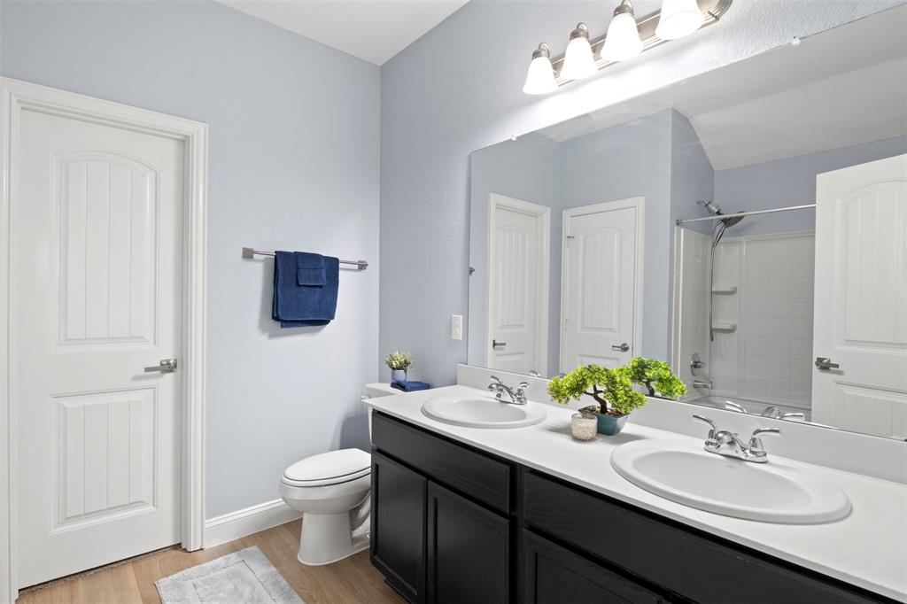 1318 Exeter Avenue Dallas, TX 75216 - Photo 9 of 31 a bathroom with a toilet a sink and mirror