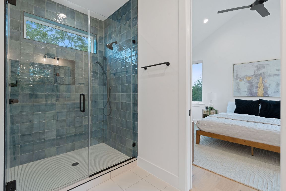 3412 Blumie Street, Unit 1 Austin, TX 78745 - Photo 21 of 39 Bathroom with a stall shower, tile patterned floors, connected bathroom, and vaulted ceiling