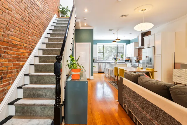 a living room with furniture kitchen view and a large window