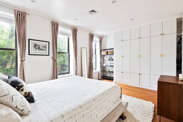 a bed sitting in a spacious bedroom next to a window