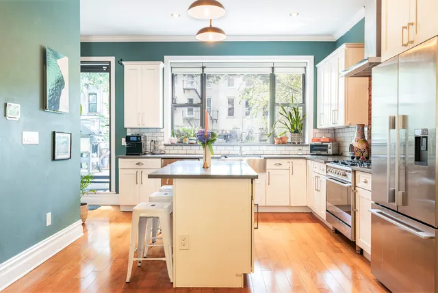 a kitchen with stainless steel appliances hardwood floor sink stove and refrigerator