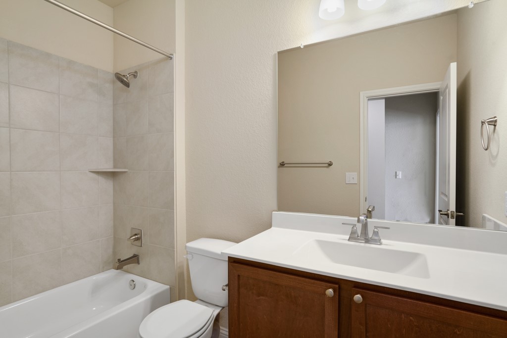 8202 Dampton Lane Austin, TX 78744 - Photo 19 of 25 a bathroom with a sink toilet vanity and shower