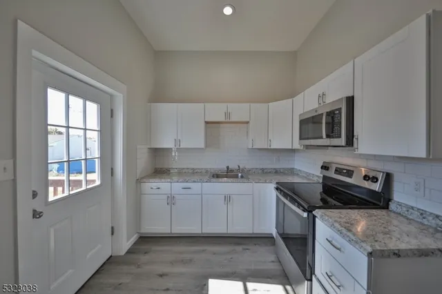 a kitchen with stainless steel appliances granite countertop a sink stove microwave and cabinets