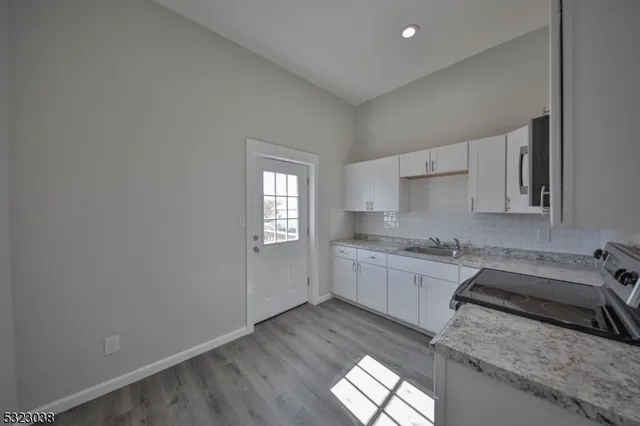 a kitchen with granite countertop white cabinets and white appliances