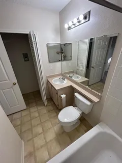 a bathroom with a sink toilet and mirror