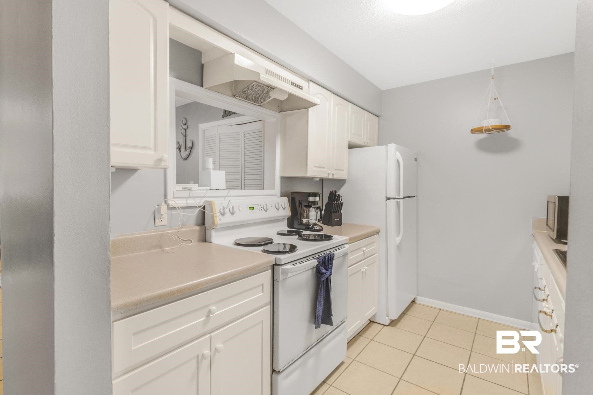 110 5th Street, Unit A 103 Daphne, AL 36526 - Photo 14 of 28 Kitchen featuring light tile patterned floors, white appliances, and white cabinetry