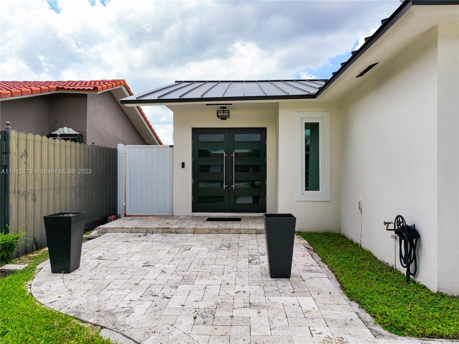 13821 Southwest 14th Street Miami, FL 33184 - Photo 3 of 58 a front view of a house with garden