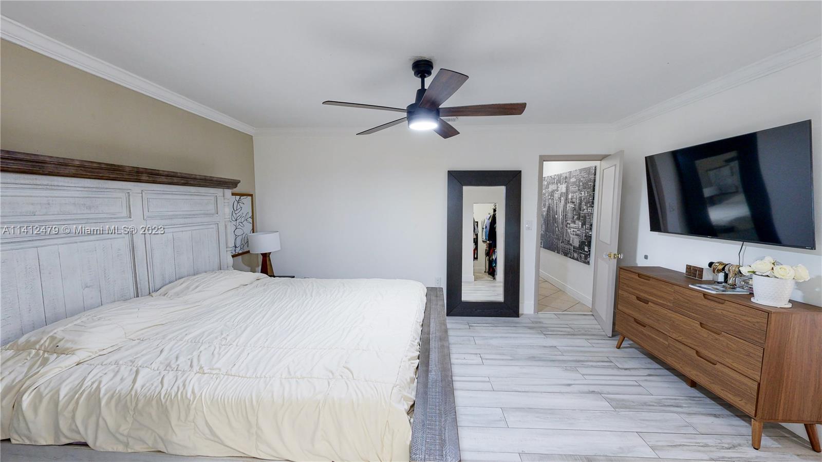 13821 Southwest 14th Street Miami, FL 33184 - Photo 34 of 58 a bedroom with a bed and a flat tv screen on dresser
