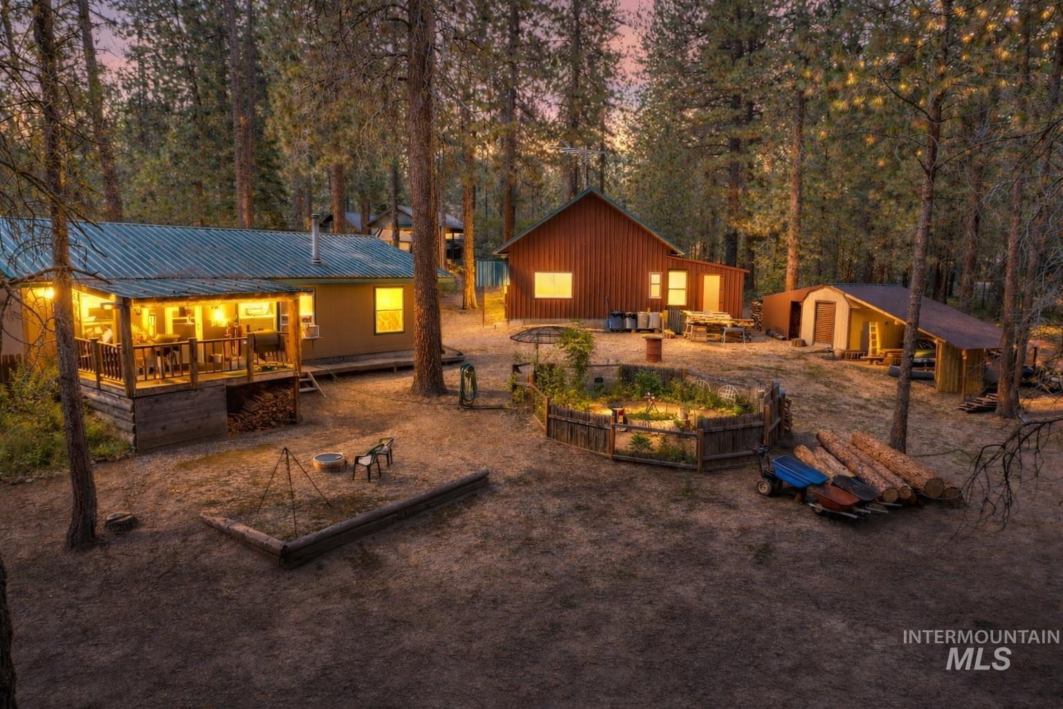 Back of house with an outdoor structure, a vegetable garden, a metal roof, and a wooden deck