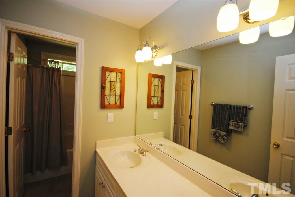 8805 Braceridge Road Raleigh, NC 27613 - Photo 18 of 25 a bathroom with a sink vanity and mirror